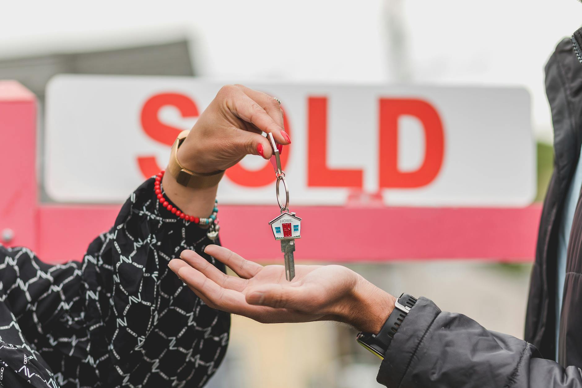 Homeowner handing over keys at the close of a successful home sale.