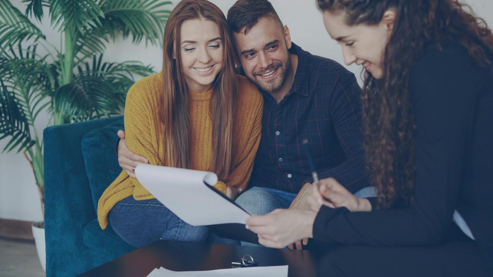 Couple reviewing a closing disclosure document at a table — the moment most buyers see their full closing costs for the first time.