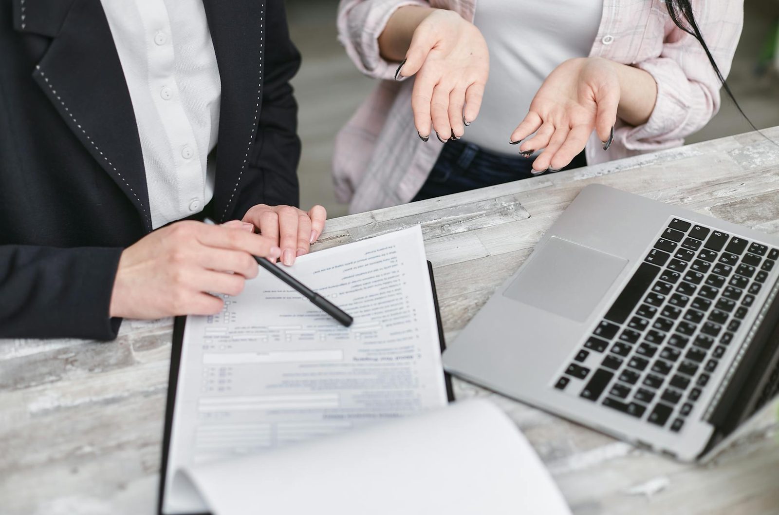 Stack of mortgage paperwork with a pen on top — the Loan Estimate is your single most important closing-cost document.
