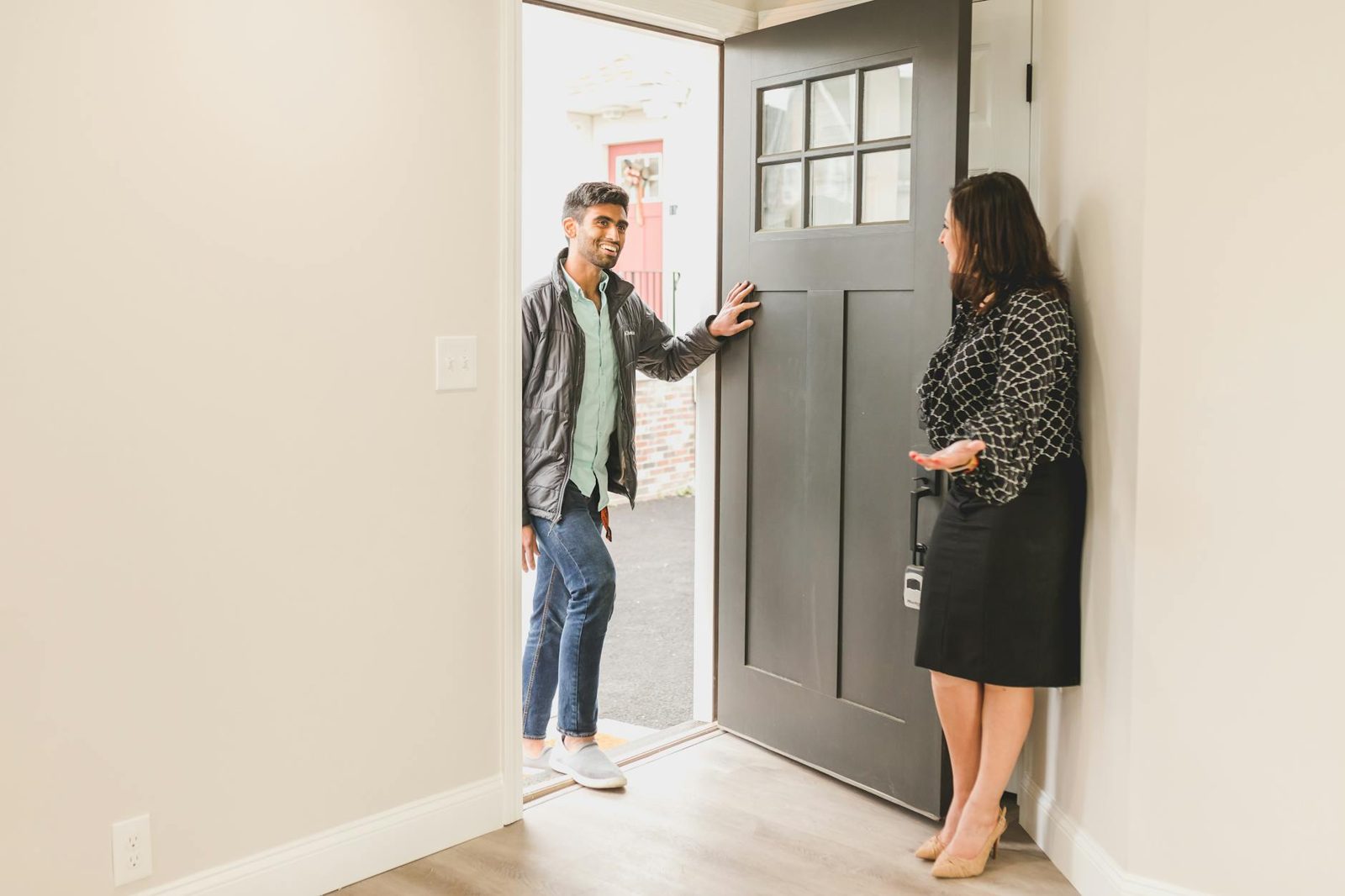 Buyer and real estate agent walking through a home interior — touring decisions in summer compress to hours, not days.