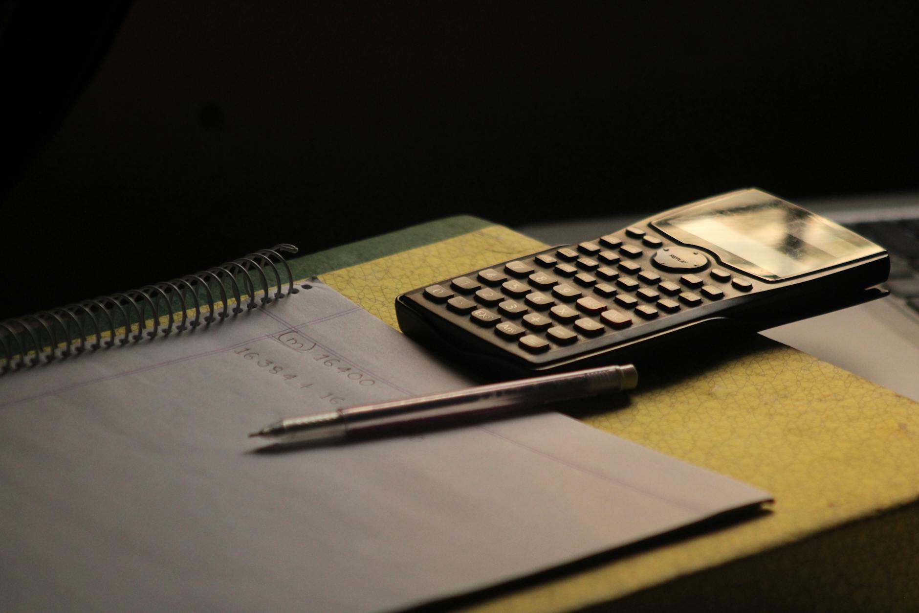 Calculator, notebook, and coffee mug on a desk — running the real rent-versus-buy numbers.