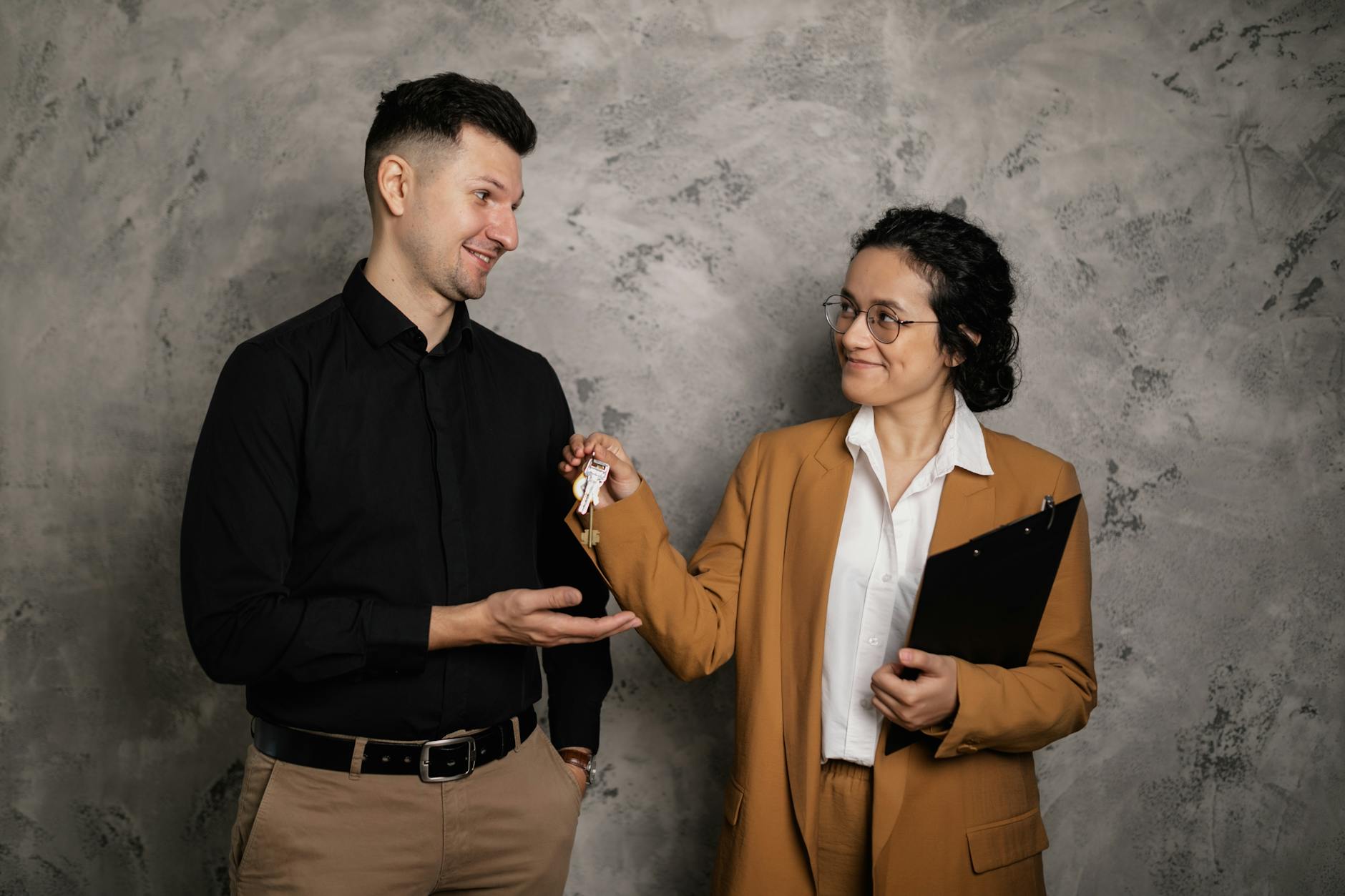 Real estate agent handing buyer the keys at a closing table — seller concessions negotiated up front can shift thousands.