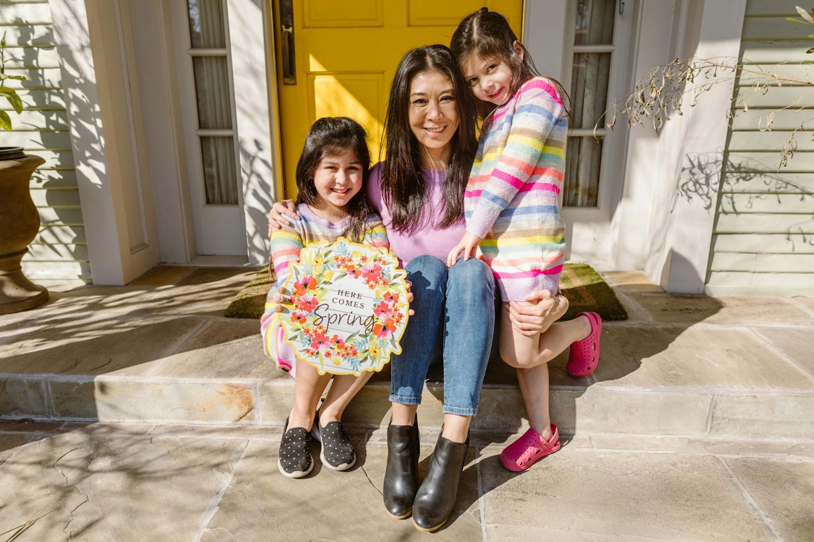 Family on the front porch of a home at golden hour — the non-financial side of the homeownership decision.