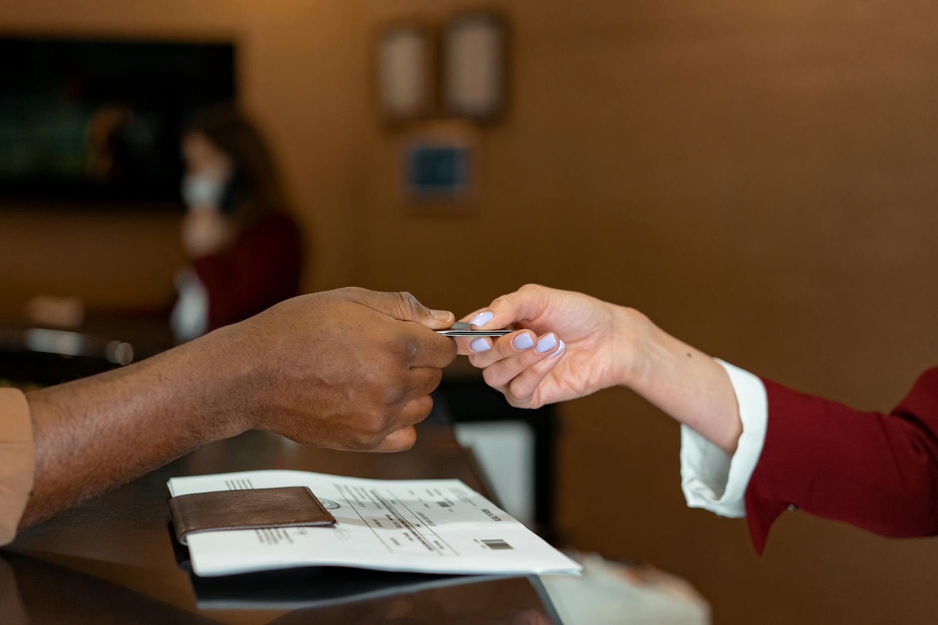 Hand passing closing funds across a table — the cash-to-close moment, smaller when the work was done up front.