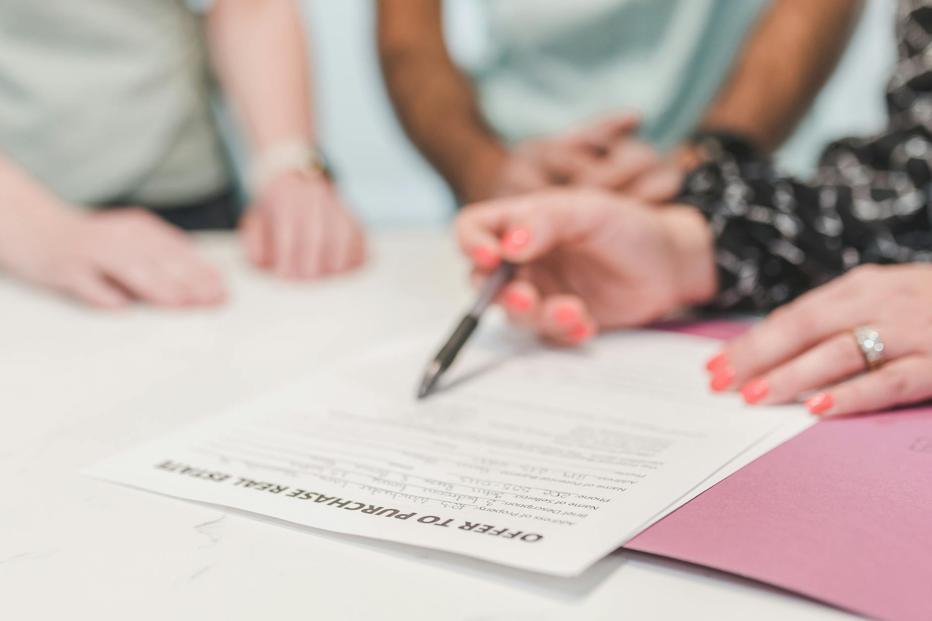 Real estate agent reviewing paperwork with home buyer — pricing on comps, not hope.