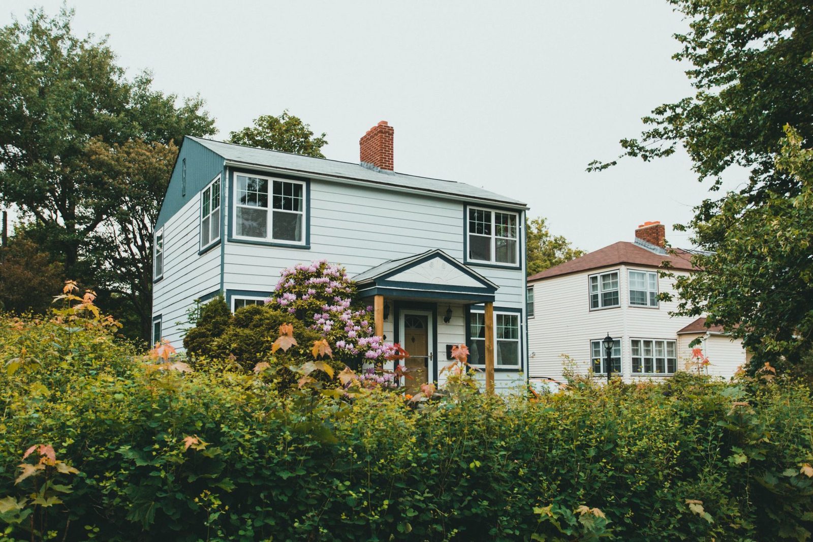 Two residential homes representing the buy-before-sell or sell-before-buy decision