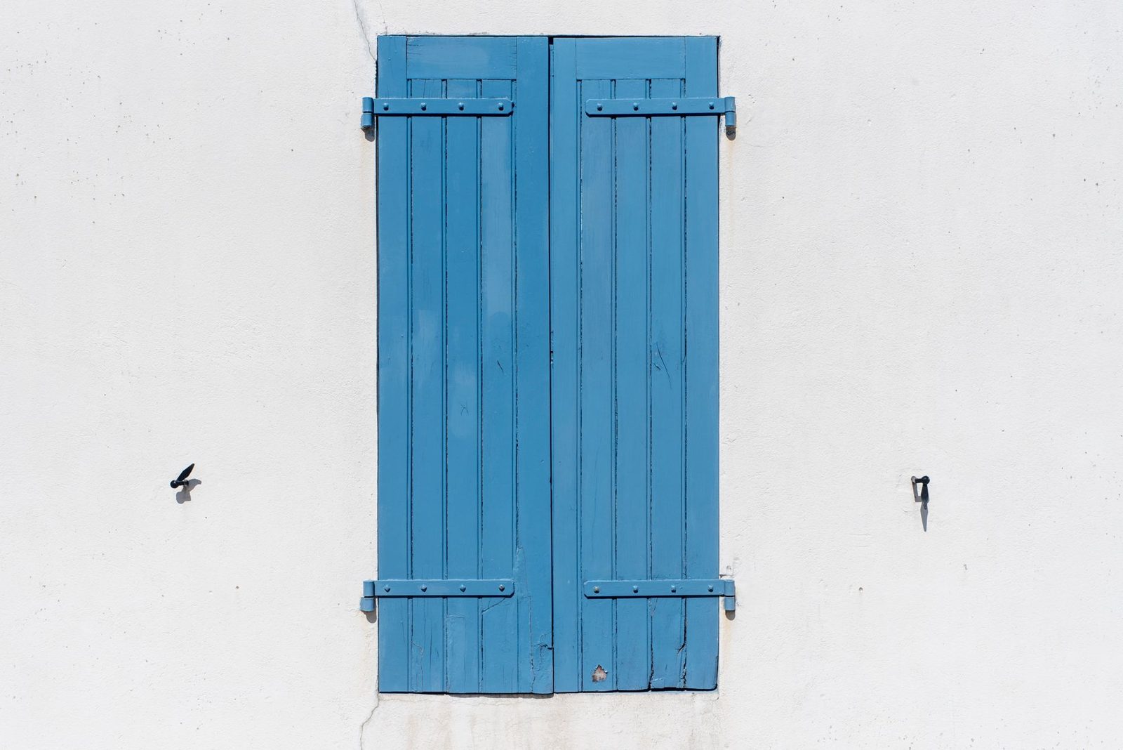 A coastal home with storm shutters — a reminder that wind and hail are handled specially in coastal policies.