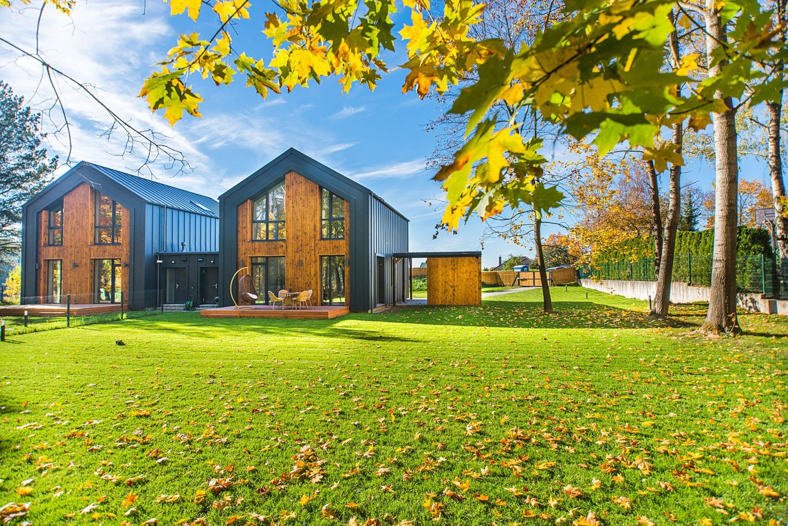 Residential home exterior in fall with leaves on the ground representing seasonal maintenance