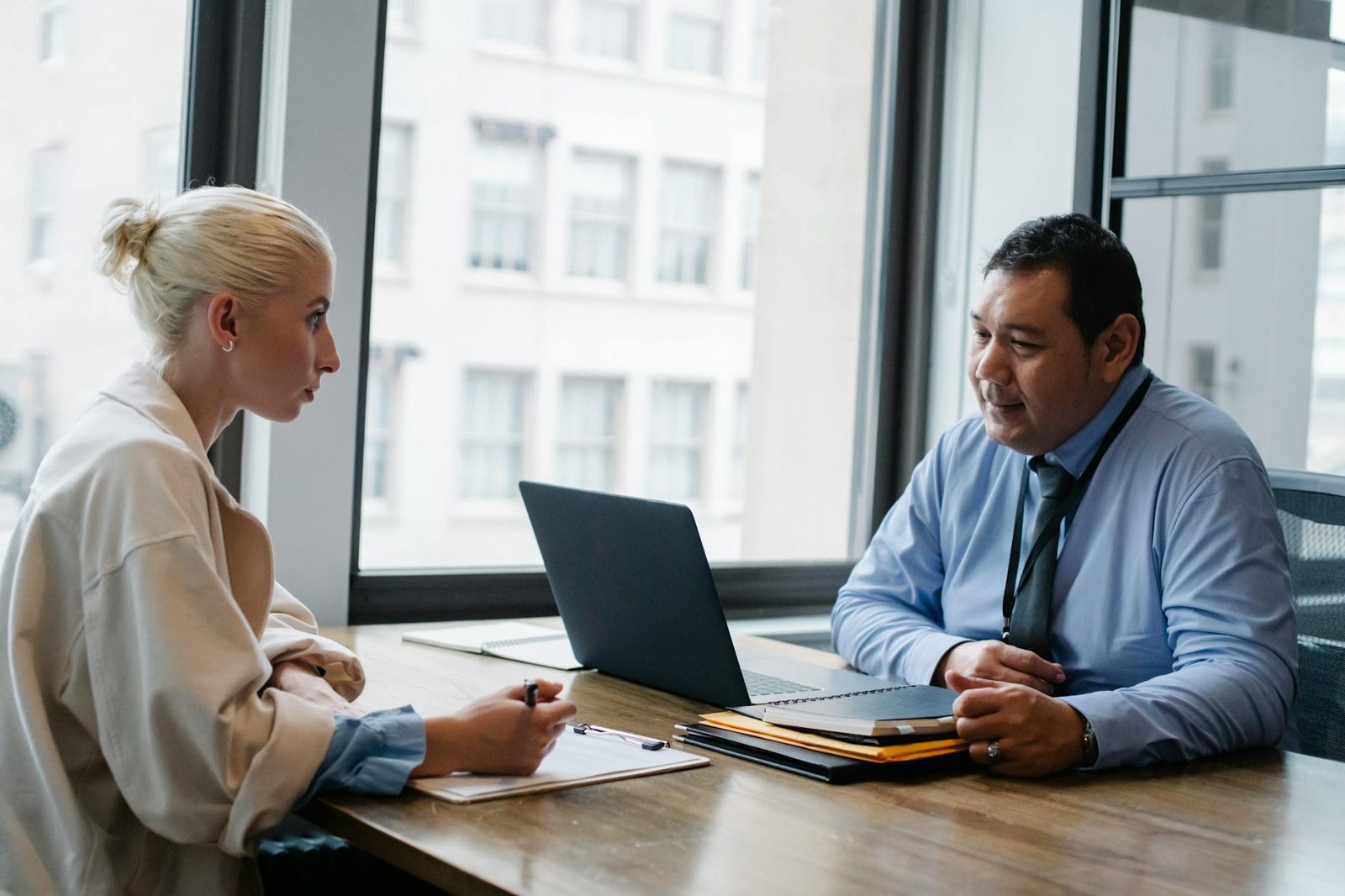 A homeowner interviewing a real estate agent across a table — comparing professionals before choosing.