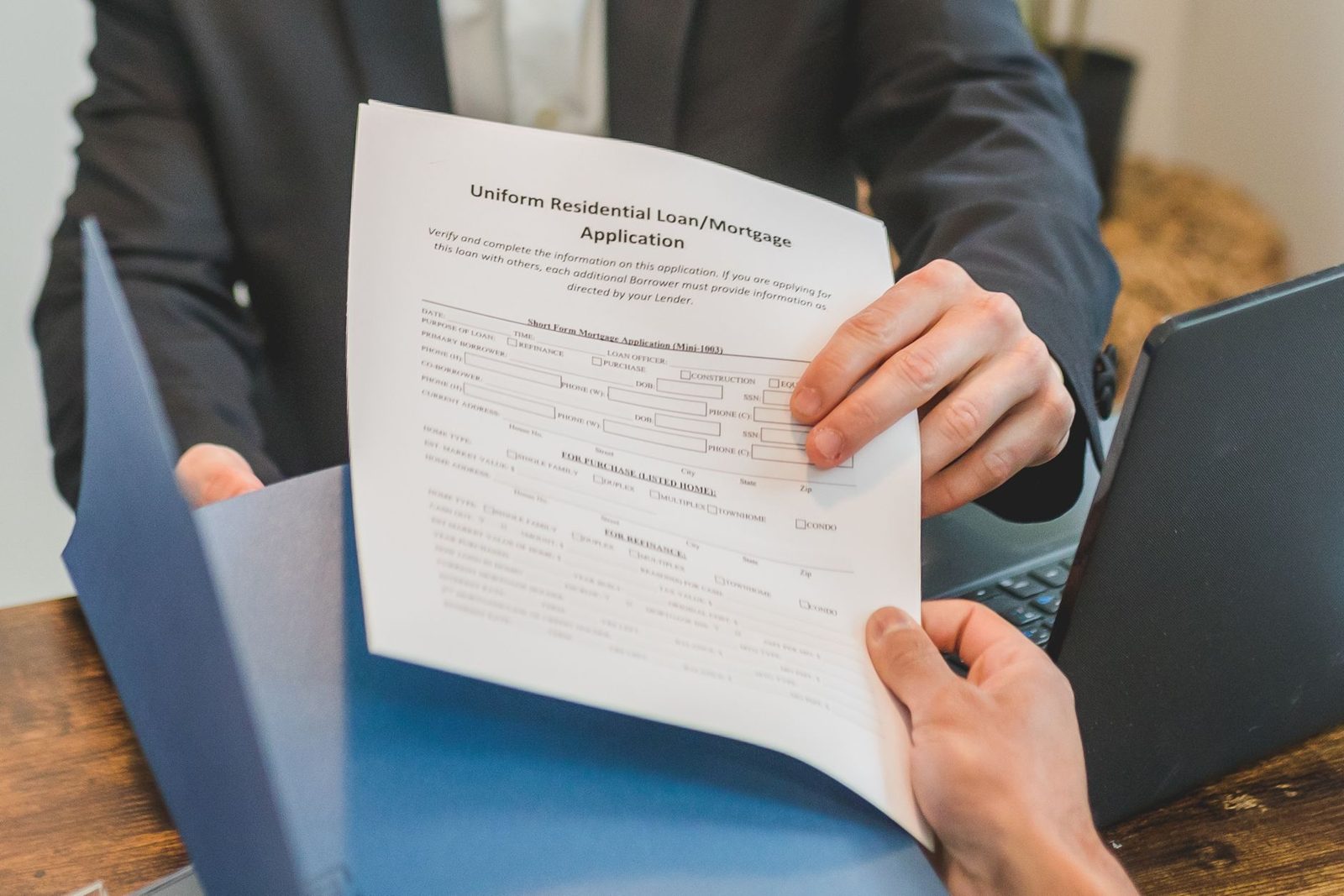Underwriter reviewing financial loan documents at an office desk