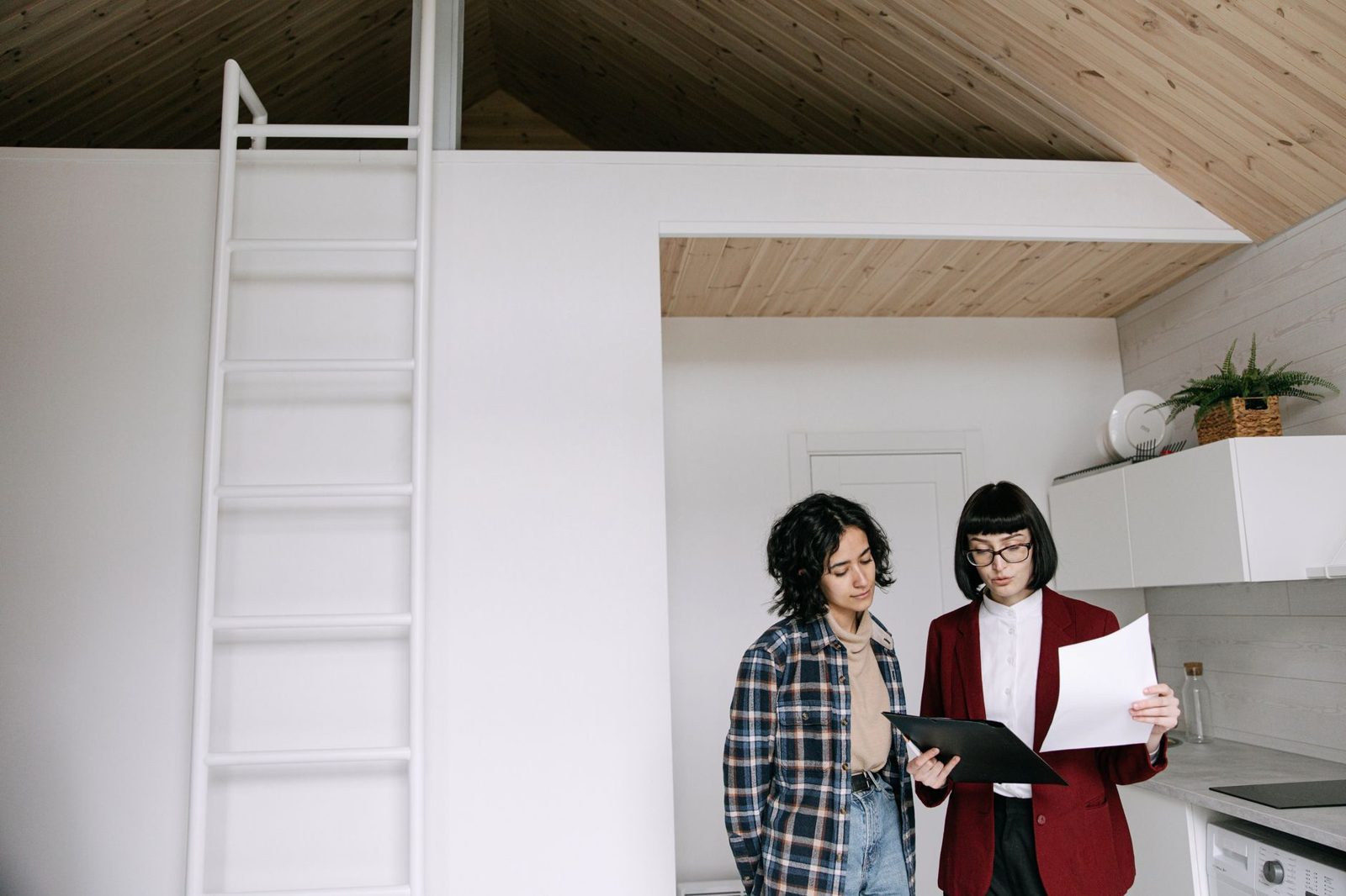 Two people reviewing a checklist during a home sale evaluation