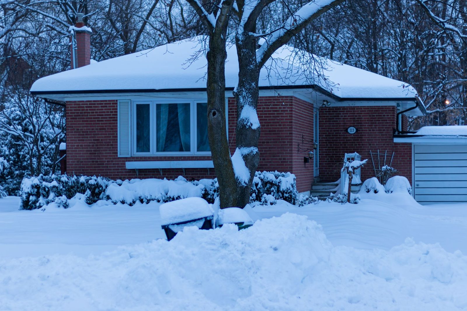 Ice dam forming along the roofline of a residential home in winter