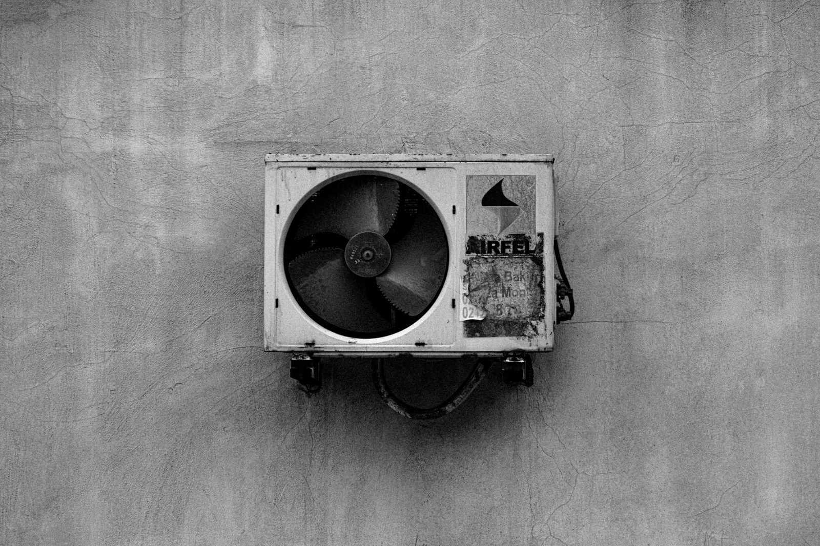 An HVAC outdoor condenser unit with leaves and debris that needs to be cleared for proper airflow.