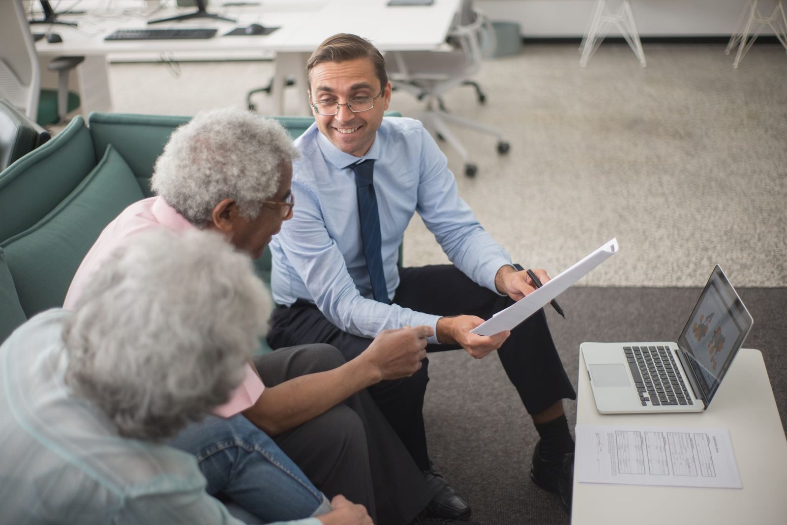 A couple reviewing insurance and tax figures with an advisor before buying a coastal home.