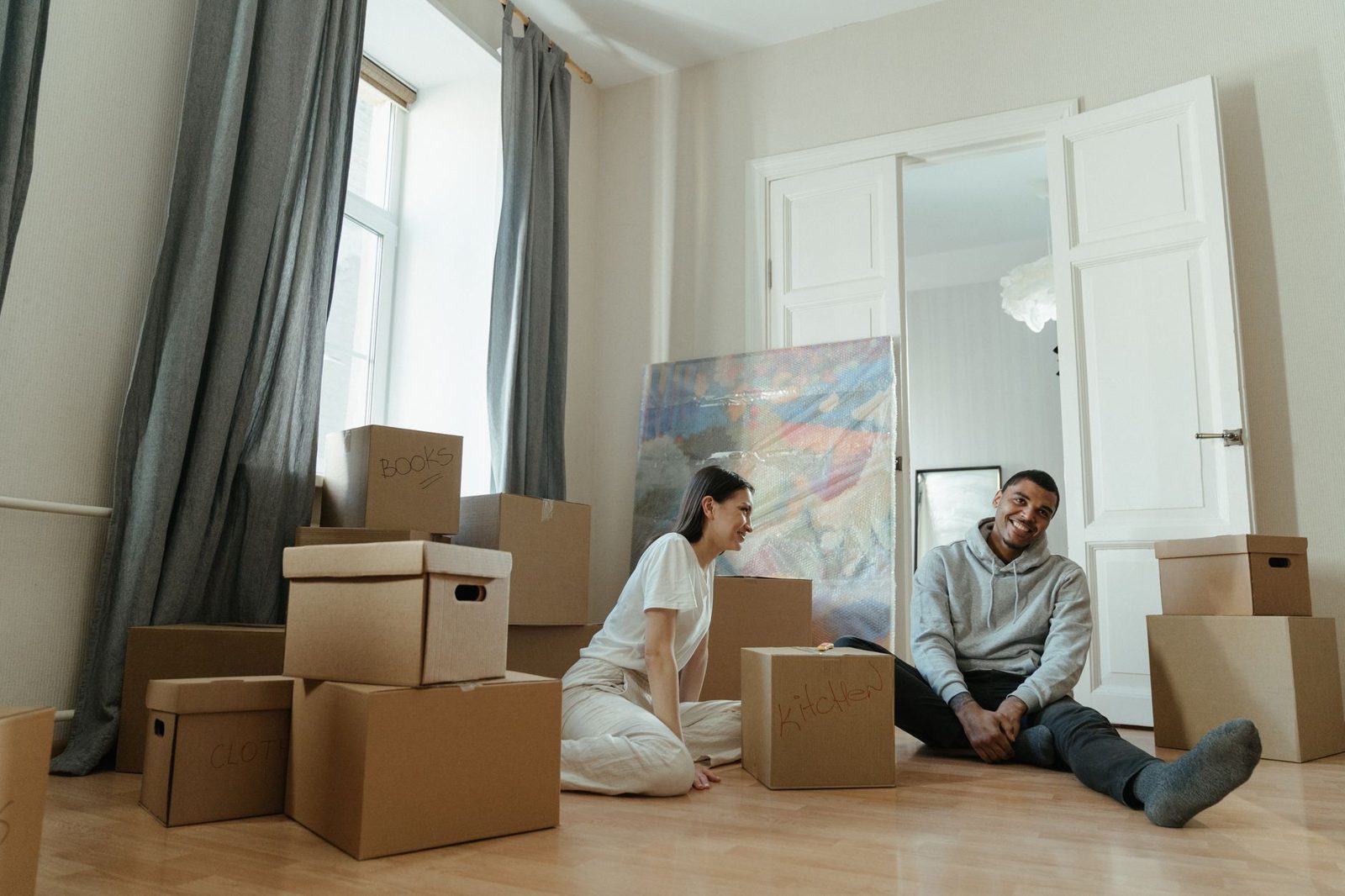 Couple surrounded by moving boxes planning their home transition