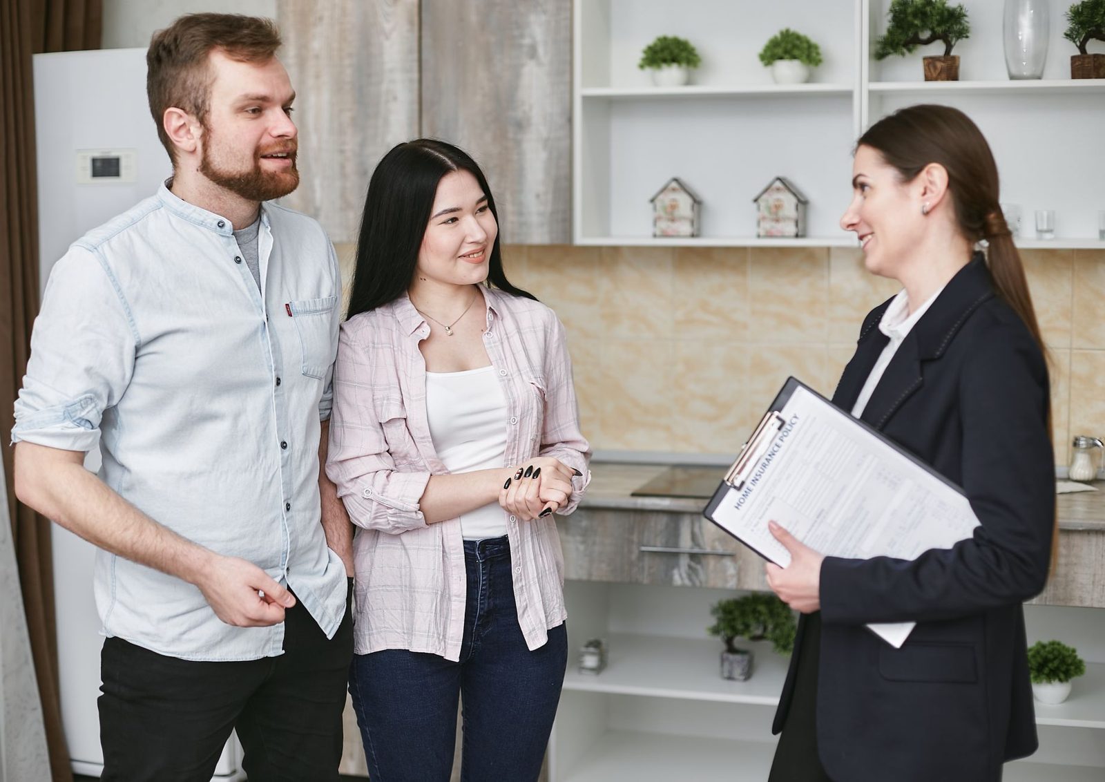 Couple smiling while signing home sale documents