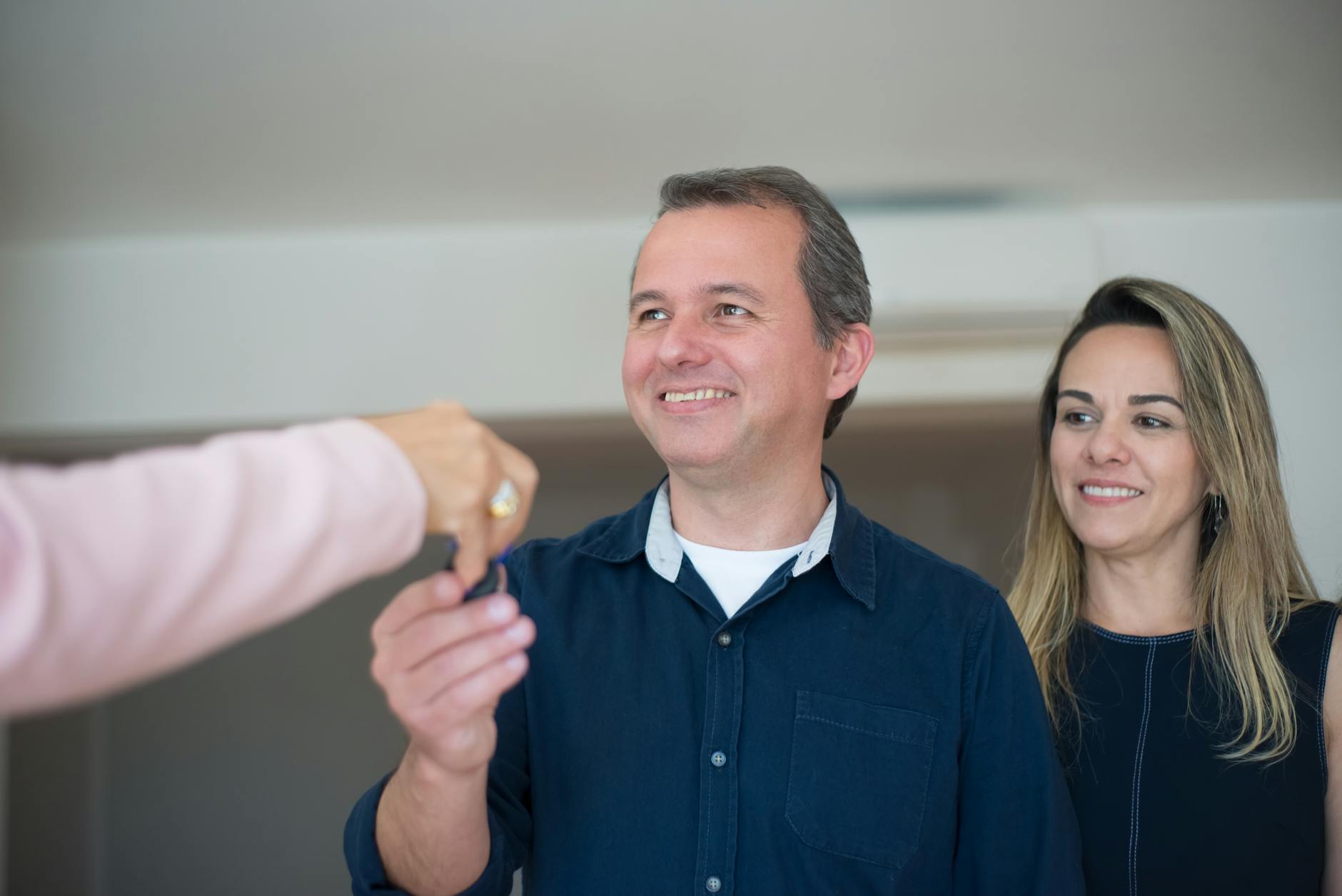 Satisfied clients holding keys after a smooth transaction — the payoff of choosing the right agent.