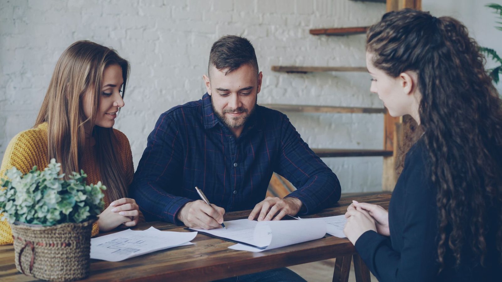 Couple discussing negotiation options with their real estate agent