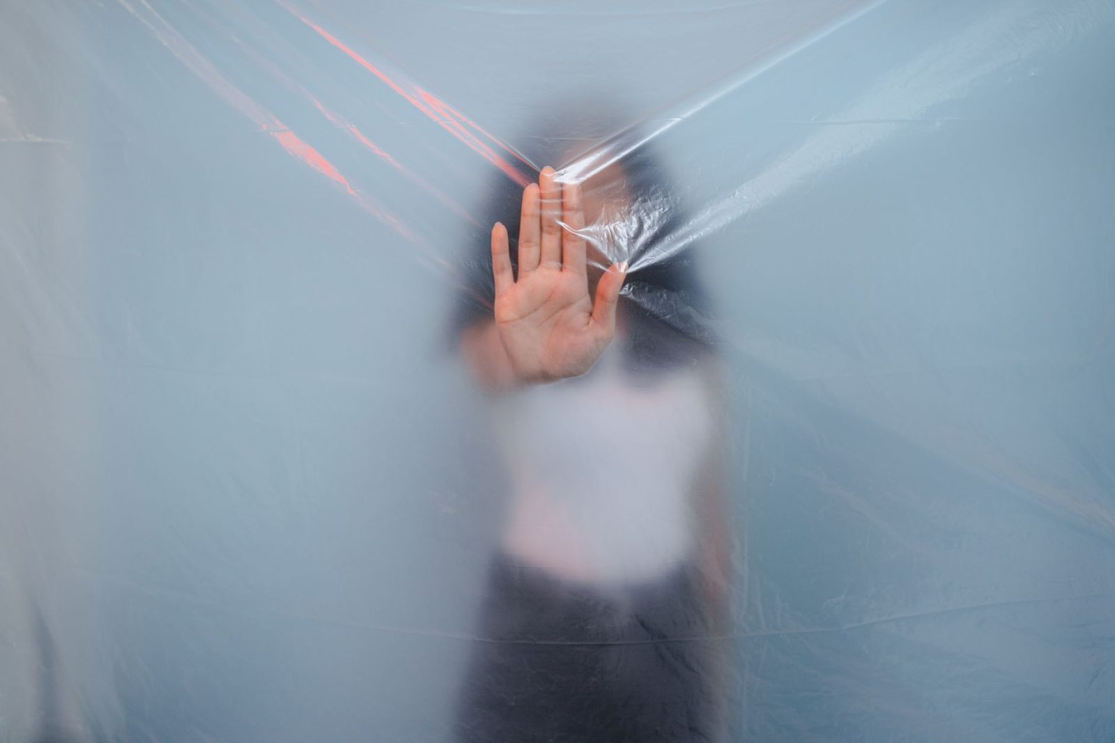 A technician installing vapor barrier plastic sheeting in a home crawl space