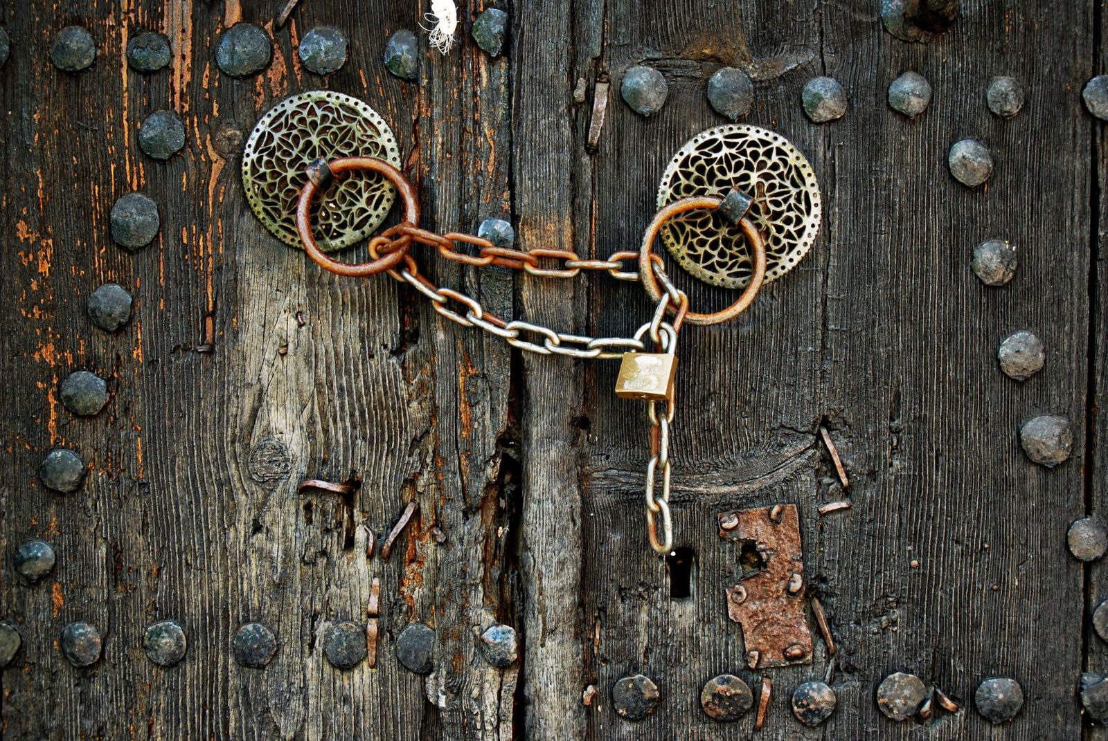 A metal chain and padlock secured on a wooden door, symbolizing clear title
