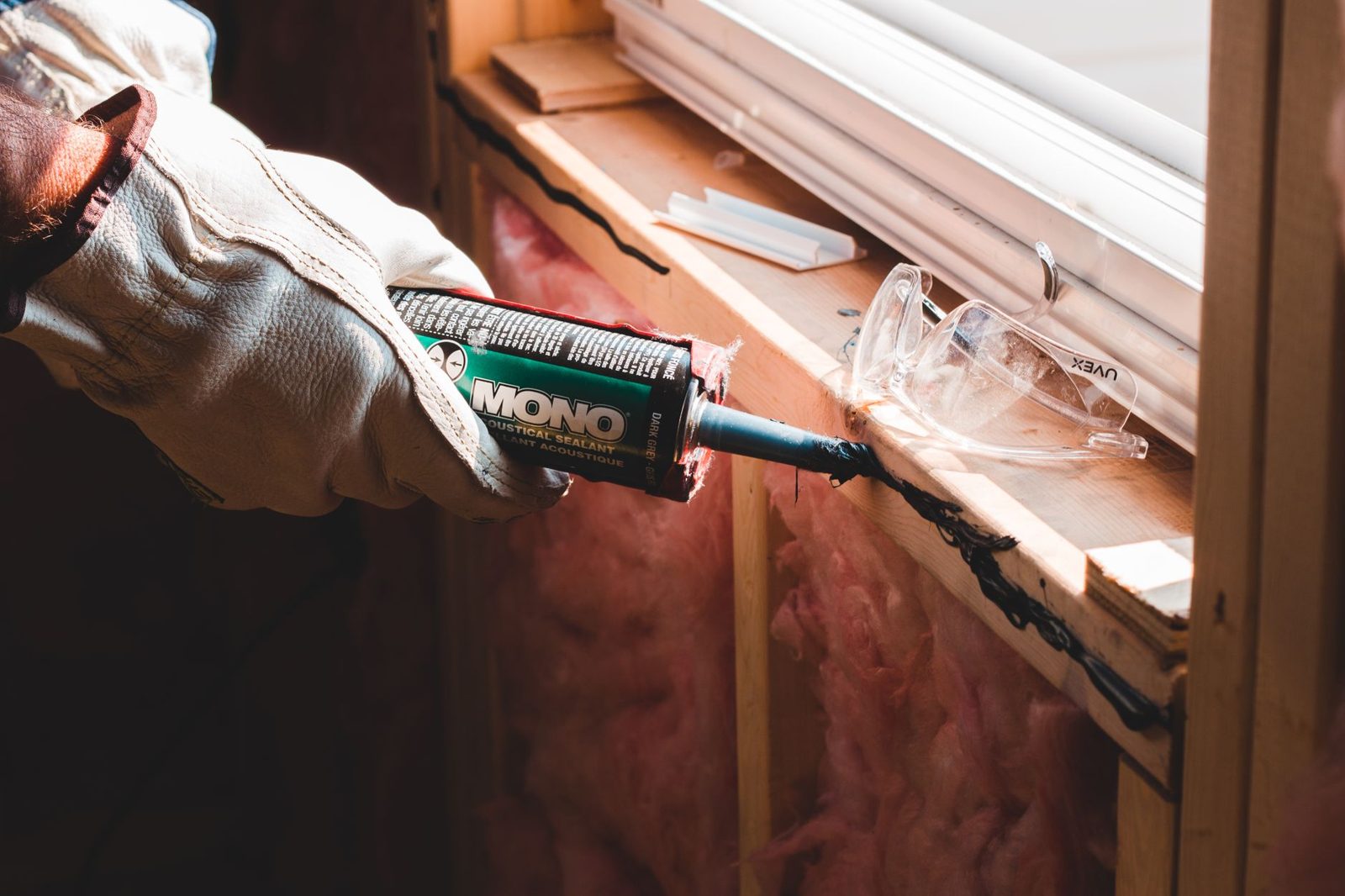 Contractor applying caulk around an exterior window trim